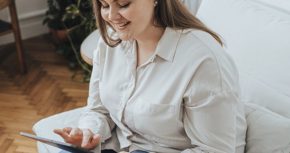 Woman is looking at SEO Reports on her tablet at home